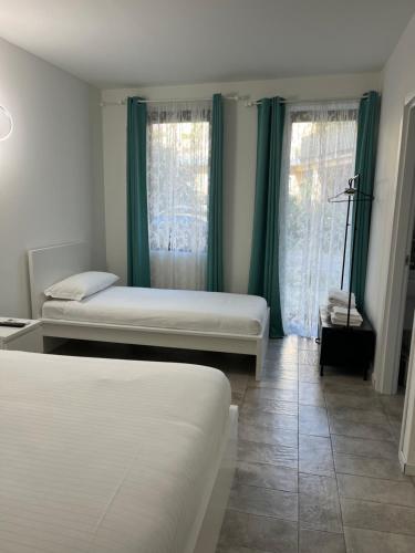 a bedroom with two beds and green curtains at Seriana in Orio al Serio