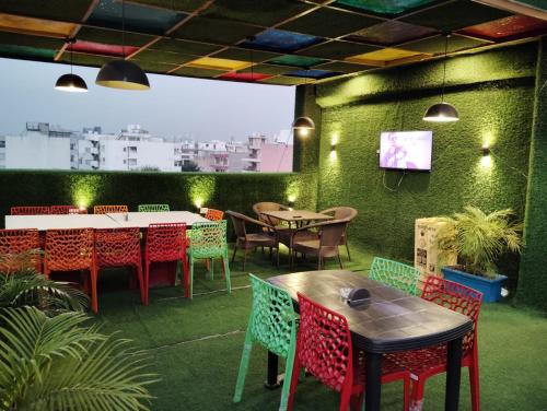 a restaurant with tables and chairs and a tv on a wall at Mallenzo suites in Gurgaon