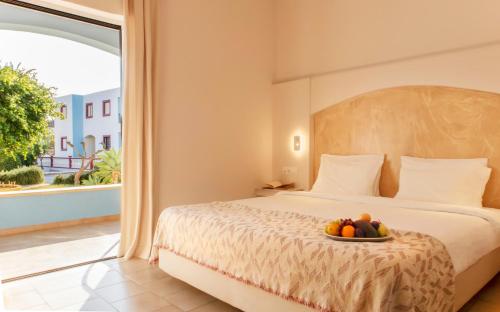una camera da letto con un letto e un cesto di frutta; di Hotel Marilen ad Alinda