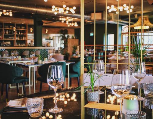 a table with wine glasses on it in a restaurant at Havendijk Hotel in Schiedam