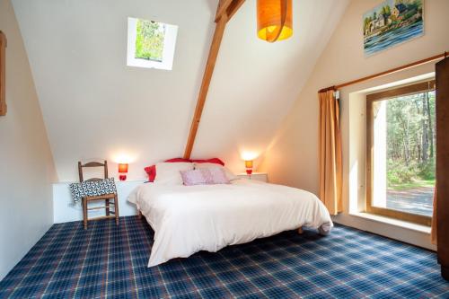 1 dormitorio con cama y ventana grande en Maison forestière en Plouézec