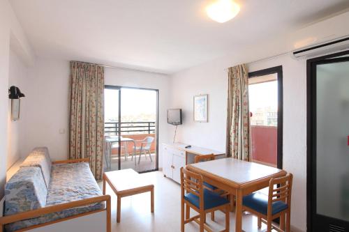 a hotel room with a bed, table and chairs at Apartamentos La Caseta - SABESA in Benidorm