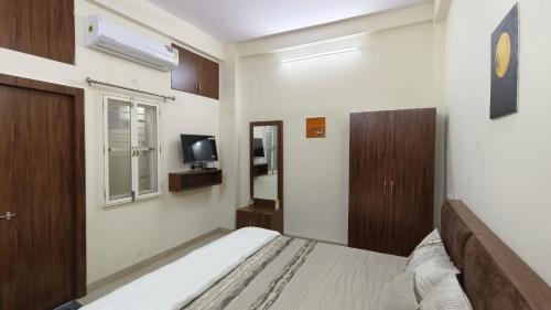 een slaapkamer met een bed en een tv. bij Sukoon The Legacy in Ujjain