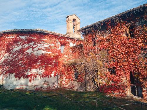 un vecchio edificio con foglie rosse sopra di Castello di Baccaresca a Branca