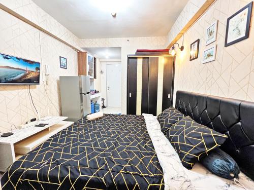 - une chambre avec un lit et un bureau dans l'établissement Cozy Studio 1BR at Green Bay Pluit Apartment, à Jakarta