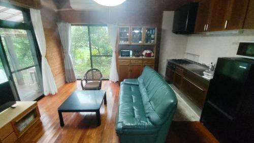 sala de estar con sofá verde y mesa en Whole house rental inn Horizon line - Vacation STAY 18087v en Yakushima