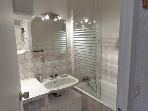 een witte badkamer met een wastafel en een douche bij Studio au cœur du Sauze - La grande Chaume in Enchastrayes