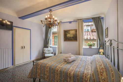 sypialnia z łóżkiem i żyrandolem w obiekcie Rooms Corte Delle Uova Centro Storico Piazza San Michele w Lukce