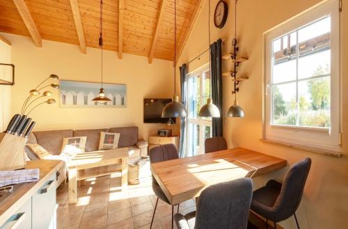a kitchen and living room with a wooden table and chairs at Blau am See in Jabel