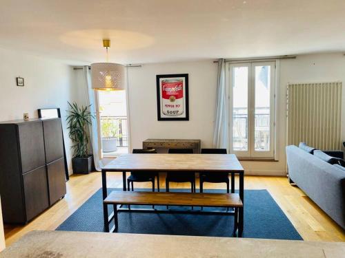 un salon avec une table et un canapé dans l'établissement Hypercentre Clermont-FD terrasse + parking, à Clermont-Ferrand