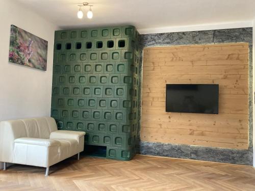 a living room with a couch and a flat screen tv at Ansitz Hofer in Fulpmes