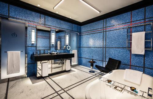 a blue bathroom with a tub and a sink at Dinamo Hotel Baku in Baku