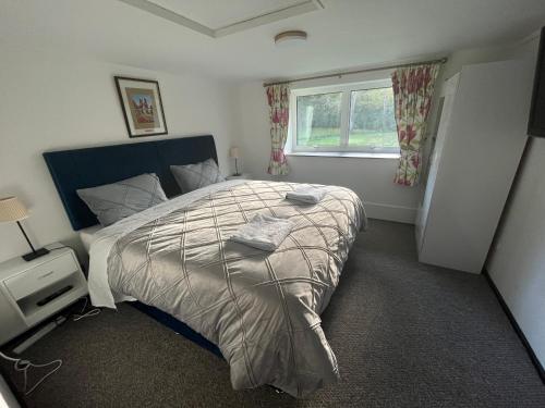 a bedroom with a large bed and a window at Yu’s Guest House in Sevenoaks
