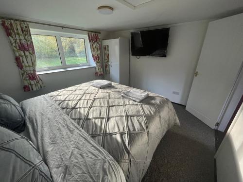 a bedroom with a bed with a comforter on it at Yu’s Guest House in Sevenoaks