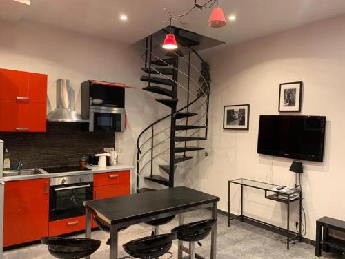 a kitchen with a spiral staircase in the wall at 21 Atelier Chaplin Montorgueil in Paris