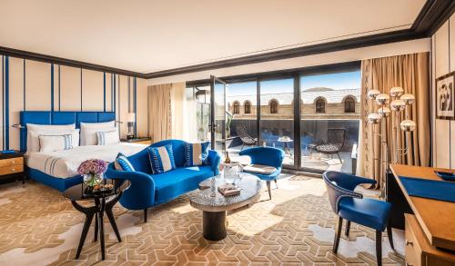 Dinamo Hotel Baku في باكو: غرفة فندق بسرير وكراسي زرقاء