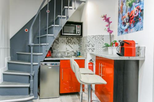 une cuisine avec des armoires orange et un escalier dans l'établissement 25 - Fun Duplex in Montorgueil, à Paris