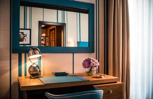 a desk with a mirror and a chair in a room at Dinamo Hotel Baku in Baku