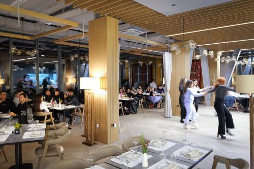 a restaurant with two people dancing in a dining room at Hotel Uji Ftohte Tepelene in Tepelenë