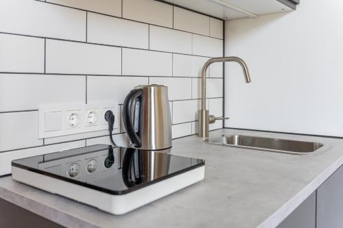 Il comprend une cuisine équipée d'une cuisinière et d'un évier. dans l'établissement Prestigious Former Library Apartment - Perfect Location, à Riga