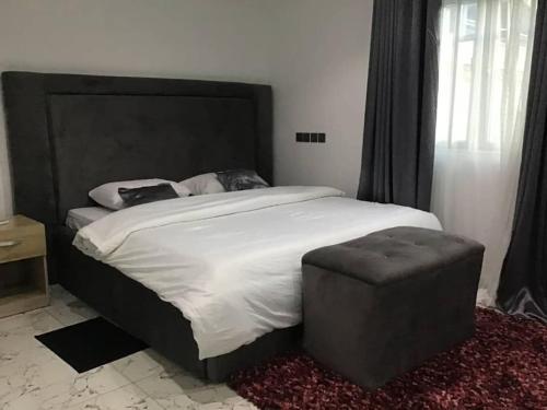 a bedroom with a large bed with a black headboard at Brandison Apartments in Rumodome