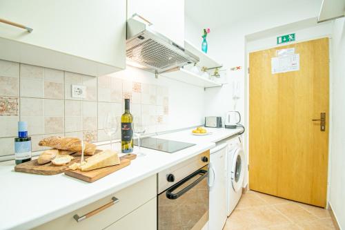 a kitchen with a counter with bread and a bottle of wine at Umag center apartment parking by Rentistra in Umag