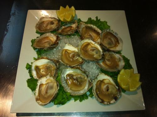 a plate of oysters with lemon slices and lettuce at Hotel Norat Marina & Spa 4* Superior in O Grove