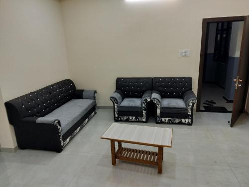 a living room with two couches and a coffee table at Shiv Shakti Homestay in Ujjain
