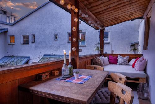 a wooden table on a balcony with a couch at Appartement Central in Hall in Tirol