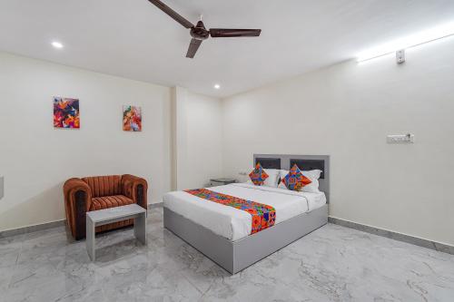 a white bedroom with a bed and a chair at FabHotel Ivory Pearl in Bangalore