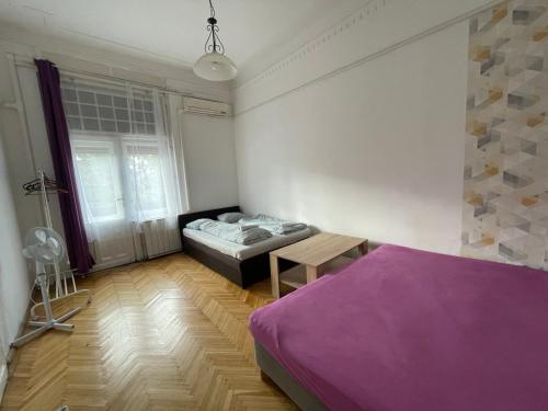 a bedroom with a bed and a table in it at White Pearl Rooms in Budapest