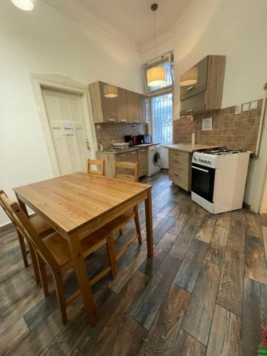 a kitchen with a wooden table and a stove at White Pearl Rooms near Gozsdu in Budapest