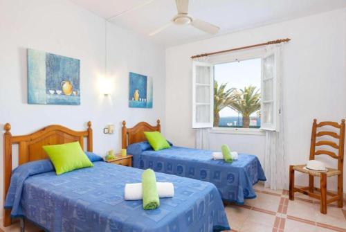 sypialnia z 2 łóżkami i oknem w obiekcie Villa Mar Azul w mieście Arenal d'en Castell