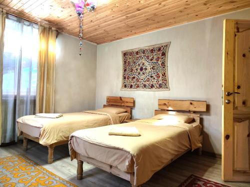 a room with two beds and a window at Evergreen Guesthouse in Karakol