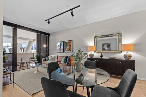 a living room with a glass table and chairs at South Bank Sensational! ~ 1Bed,1Bath,1Car,Balcony in Brisbane