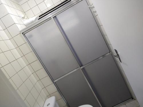 eine Glastür im Bad mit WC in der Unterkunft Bate & Volta - Apartamentos com 2 quartos próximo ao SESC Bertioga in Bertioga