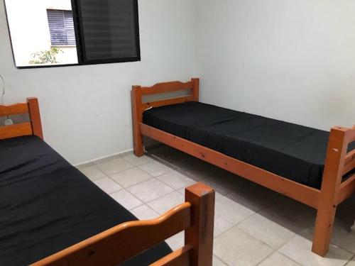 Katil atau katil-katil dalam bilik di Bate & Volta - Apartamentos com 2 quartos próximo ao SESC Bertioga