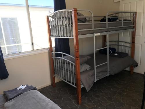 2 Etagenbetten in einem Zimmer mit Fenster in der Unterkunft Australian Hotel Winton Cabins in Winton
