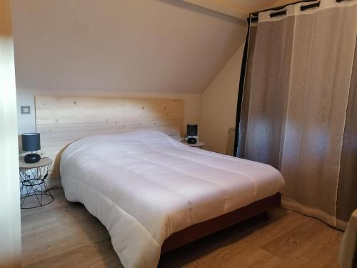 une chambre avec un grand lit blanc dans une pièce dans l'établissement Appartement Pyrénées Sainte-marie de campan proche la Mongie avec parking couvert privatif, à Campan