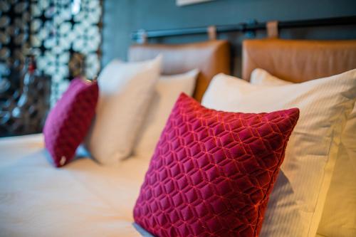 two red pillows sitting on top of a bed at Two Brothers Noordwijk Beach in Noordwijk aan Zee