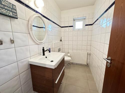 uma casa de banho com um lavatório, um WC e um espelho. em Spacious and Family Friendly 4brd house in Hafnarfjörður em Hafnarfjördur