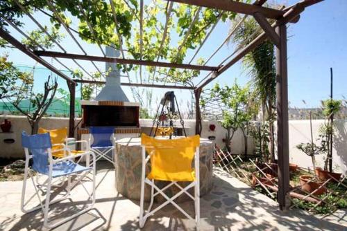 a patio with chairs and a piano under a pergola at Deep Blue Studios in Logaras