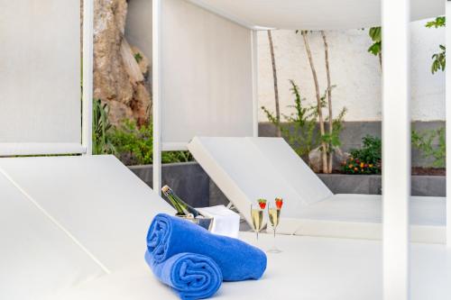 Habitación blanca con 2 camas y toalla azul en Apartamentos Altair, en Puerto Rico de Gran Canaria