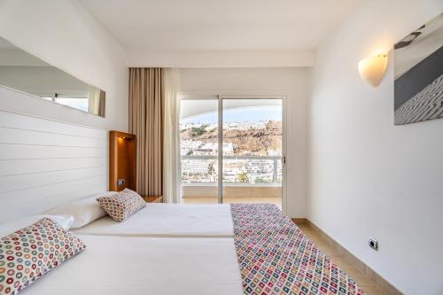 Habitación de hotel con cama y ventana en Apartamentos Altair, en Puerto Rico de Gran Canaria