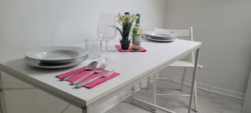 una mesa blanca con platos y utensilios. en Berg Messe DG 1Zi, K,D,B Parkplatz, W-Lan, Homeoffice, en Bergisch Gladbach