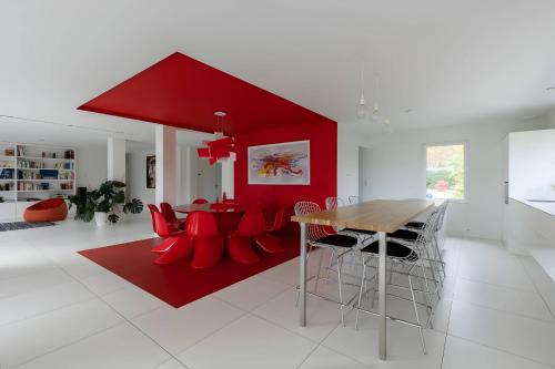 un salon avec une table et des chaises rouges dans l'établissement Villa Isaac - Luxueuse - Parking - 16p - Rêve au Mans, au Mans