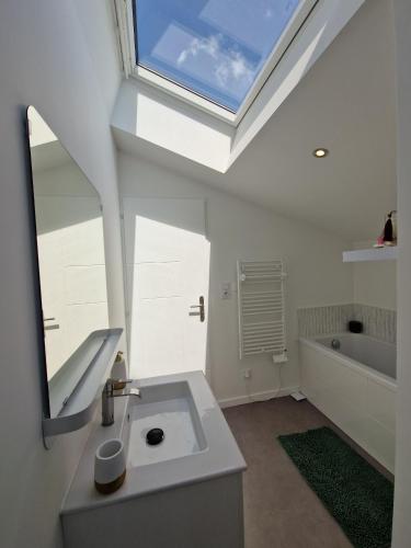 a bathroom with a white sink and a skylight at Le Saphir - Centre - Confort - 6p - Rêve au Mans in Le Mans