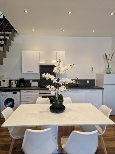 une cuisine avec une table avec un vase de fleurs dessus dans l'établissement Le Saphir - Centre - Confort - 6p - Rêve au Mans, au Mans