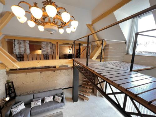 a chandelier hangs above a staircase in a room at L'Industriel - Jardin - 6 personnes - Rêve au Mans in Connerré