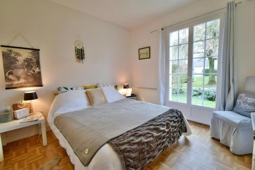 ein Schlafzimmer mit einem großen Bett und einem Fenster in der Unterkunft Le Forestier - Nature - 10p - Rêve au Mans in Bonnétable